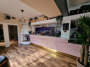 Tierp的住宿－Gästis Tierp，餐厅内的酒吧,有粉色的柜台