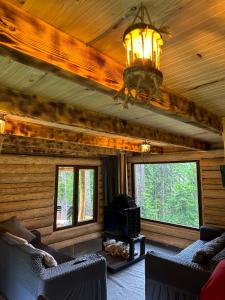 a living room in a log cabin with a chandelier at Hut In Hatsvali in Mestia