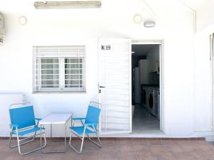 a dining room with two chairs and a table and a door at Holiday Beach Apartment in Denia