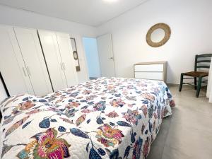 a bedroom with a bed with a quilt on it at Holiday Beach Apartment in Denia