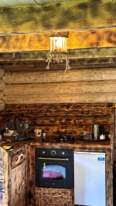 a stove top oven in a kitchen with a wooden wall at Hut In Hatsvali in Mestia