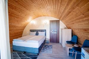 1 dormitorio con cama y techo de madera en Montana Garden, en Răşinari