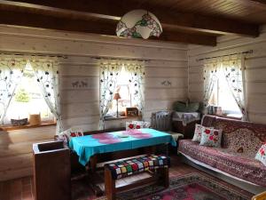 sala de estar con mesa y sofá en Buczynowe Chaty, en Wysowa-Zdrój