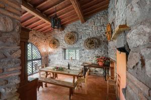 a kitchen with a table and a sink in a stone wall at Colle Degli Ulivi - pool, nature, relax holiday home Cortona, Italia in Cortona