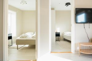 um quarto com uma cama e uma televisão num quarto em Stay Urban - Perfect location em Bergen