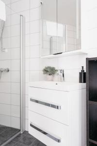 uma casa de banho branca com um lavatório e um espelho em Stay Urban - Perfect location em Bergen
