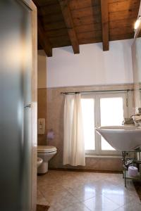 uma casa de banho com um lavatório, um WC e uma janela. em B&B Casa del Teatro em Mantova