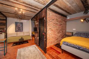 ein Schlafzimmer mit einem Bett und einer Ziegelwand in der Unterkunft Brauhaus Danube Cottage in Petrovaradin
