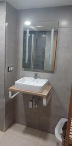 een badkamer met een wastafel en een spiegel bij Apartamento Acogedor in Moncófar