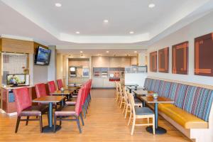 TownePlace Suites by Marriott San Bernardino Loma Linda في لوما ليندا: مطعم بطاولات خشبية وكراسي حمراء