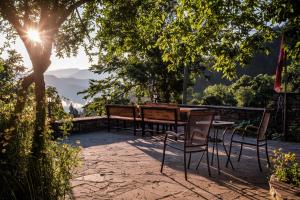 eine Terrasse mit einem Tisch und Stühlen unter einem Baum in der Unterkunft Chri Chri Guesthouse in Përmet
