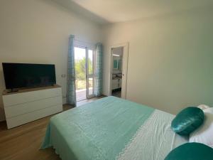 a bedroom with a bed and a flat screen tv at Villetta Palmina in Porto Azzurro