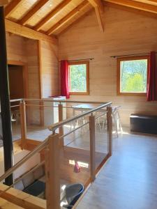 Habitación con escalera en una cabaña de madera en CHALET DES CHARBONNIERS AVEC ETANG en Saint-Maurice-sur-Moselle