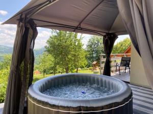 a hot tub with a canopy on a patio at Chalupa Pod Muchovem in Velké Hamry
