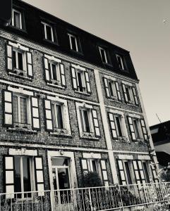 a black and white photo of a large brick building at Le Boujou - Place de parking - 200m plage in Étretat