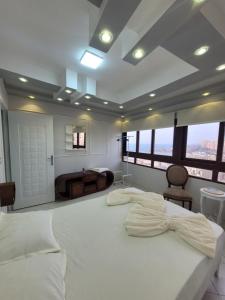 - une chambre avec un grand lit blanc et des fenêtres dans l'établissement Serine Hostel, à Alexandrie