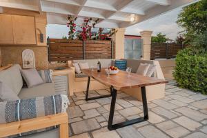 a patio with a table and a couch at Coastline maisonette near Athens Airport and Rafina Port in Artemida
