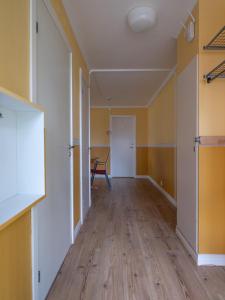 an empty room with yellow walls and wooden floors at Selmas Gård in Östra Ämtervik