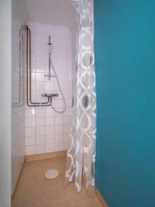 La salle de bains est pourvue d'une douche avec rideau de douche blanc. dans l'établissement Selmas Gård, à Östra Ämtervik