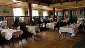 un restaurante con mesas y sillas con mantel blanco en The Seaview Tavern, en Ballygorman