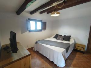 um quarto com uma cama e uma televisão de ecrã plano em Casa Cuatro Vientos em Tordera