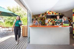 a woman standing at a counter in a kitchen at Huttopia Côte Sauvage - Ile de Ré in Sainte-Marie-de-Ré