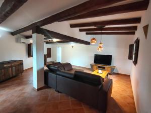 uma sala de estar com um sofá e uma televisão em Casa Cuatro Vientos em Tordera