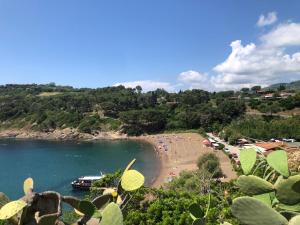 a beach with people and a boat in the water at Villetta Palmina in Porto Azzurro