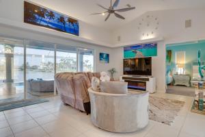 ein Wohnzimmer mit einem Sofa und einem TV in der Unterkunft Diamonds and Daiquiris - Updated Cape Coral Escape in Cape Coral