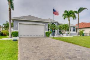 ein Haus mit einer Garage und einer amerikanischen Flagge in der Unterkunft Diamonds and Daiquiris - Updated Cape Coral Escape in Cape Coral