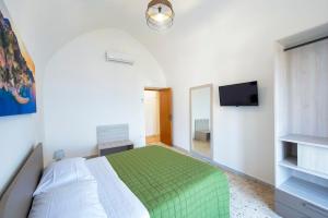 - une chambre avec un lit vert et une télévision dans l'établissement Casa Rosaria, à Conca dei Marini