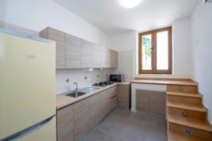 d'une cuisine avec des placards en bois, un évier et une fenêtre. dans l'établissement Casa Rosaria, à Conca dei Marini