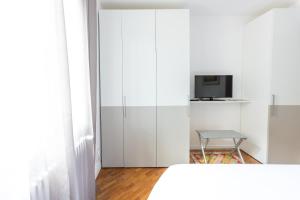a bedroom with a white bed and a tv at La casa del Vescovo in Imola