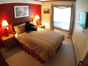 Un dormitorio con una cama con un osito de peluche. en Fireside Lodge #409 By Bear Country, en Sun Peaks