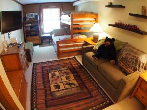 a living room with a couch with a teddy bear on it at Fireside Lodge #409 By Bear Country in Sun Peaks