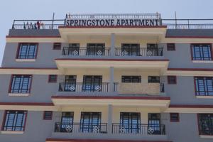 ein Gebäude mit einem Schild, das eine Springsteinwohnung liest in der Unterkunft Springstone executive apartment Rm 15 in Langata Rongai