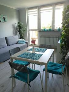 een woonkamer met een witte tafel en stoelen bij GreatHome Apartament in Zator