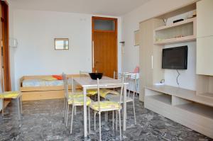 a room with a table and chairs and a bed at Condominio Al Mare in Bibione