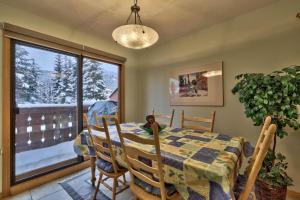a dining room with a table and chairs and a window at Snow Creek Village #20 By Bear Country in Sun Peaks