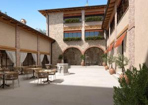un patio con mesas y sillas en un edificio en Conti Thun Wine Resort, en Puegnago sul Garda
