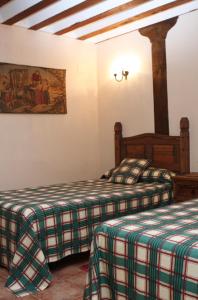 a bedroom with two beds and a painting on the wall at Casa Rural El Acebo in Almodóvar del Pinar