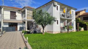 a house with a green lawn in front of it at Viktor rooms and apartments in Rovinj