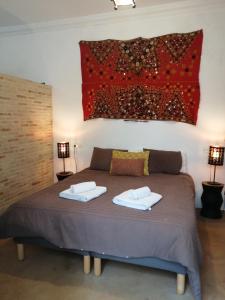 a bedroom with a bed with two towels on it at el rinconcito in Sanlúcar de Barrameda