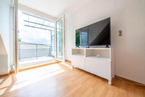 a living room with a tv and a large window at Edle DG Maisonette mit Balkon, Wohnzimmer, Arbeitszimmer, Waschmaschine, Top Ausstattung, zentral in Fürstenwalde