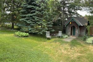 un pequeño cobertizo con 2 sillas en un patio en Cozie cottage at Niagara-On-The-Lake en Queenston