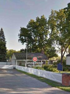 una señal para una segunda escuela en casa frente a una valla en Cozie cottage at Niagara-On-The-Lake en Queenston