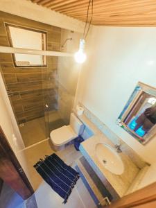 uma casa de banho com um lavatório, um chuveiro e um WC. em Chalé na Praia de Ponta Negra em Ponta Negra