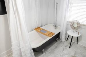 bagno bianco con vasca e tavolo di The Victorian Inn- New Listing! a Oak Hill