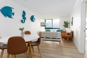 ein Esszimmer mit einem Tisch und Stühlen sowie ein Wohnzimmer in der Unterkunft Sunny BEACH FRONT 2BR Condo on the Water in San Diego