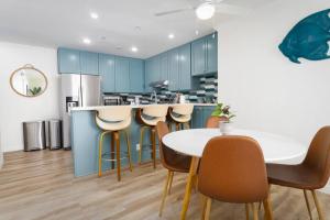 a kitchen with blue cabinets and a white table and chairs at Sunny on the Ocean - Beachfront- Pacific Beach in San Diego
